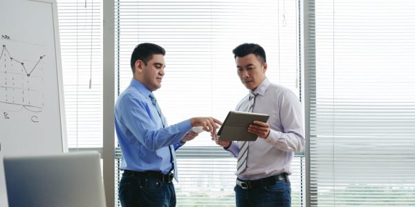 Businessmen discussing something on screen of digital tablet